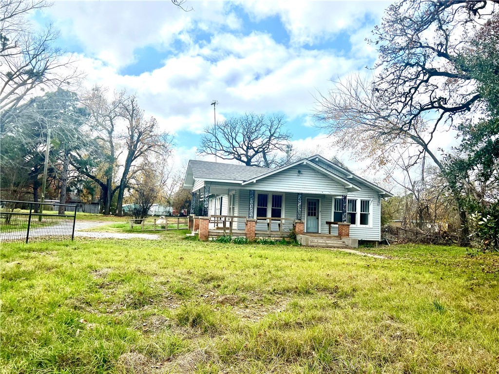 a view of a house with a big yard and large trees