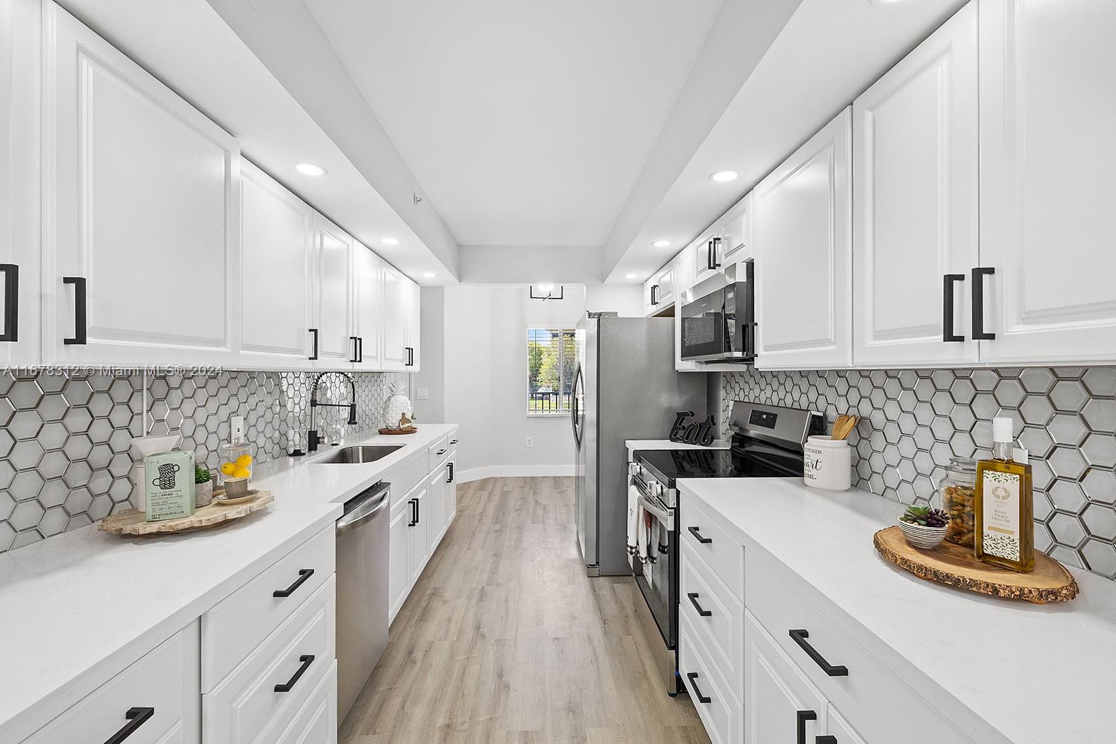 a kitchen with stainless steel appliances a sink stove top oven and cabinets