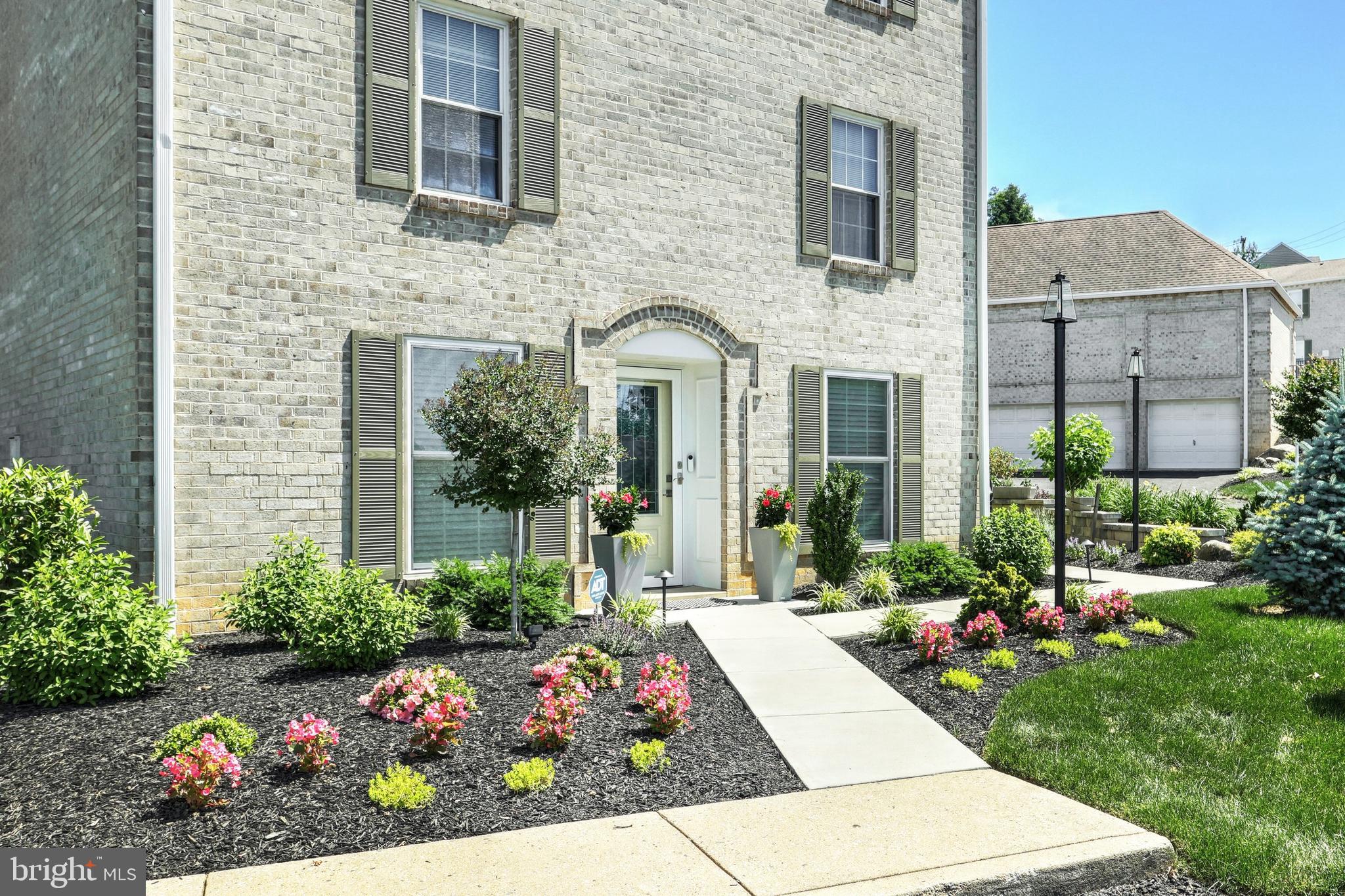 a front view of a house with a yard and fountain