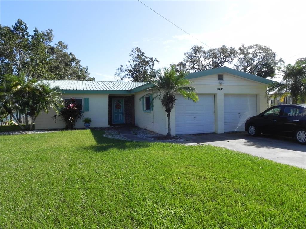 a view of a house with a yard and a garage