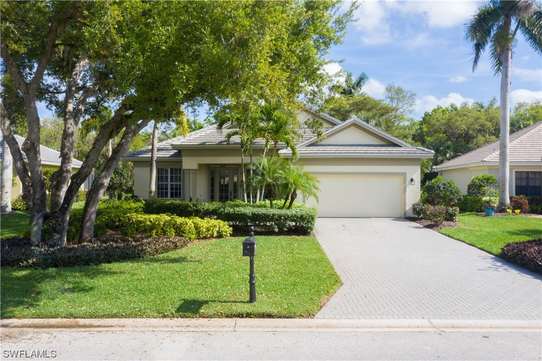 a front view of a house with a yard and potted plants