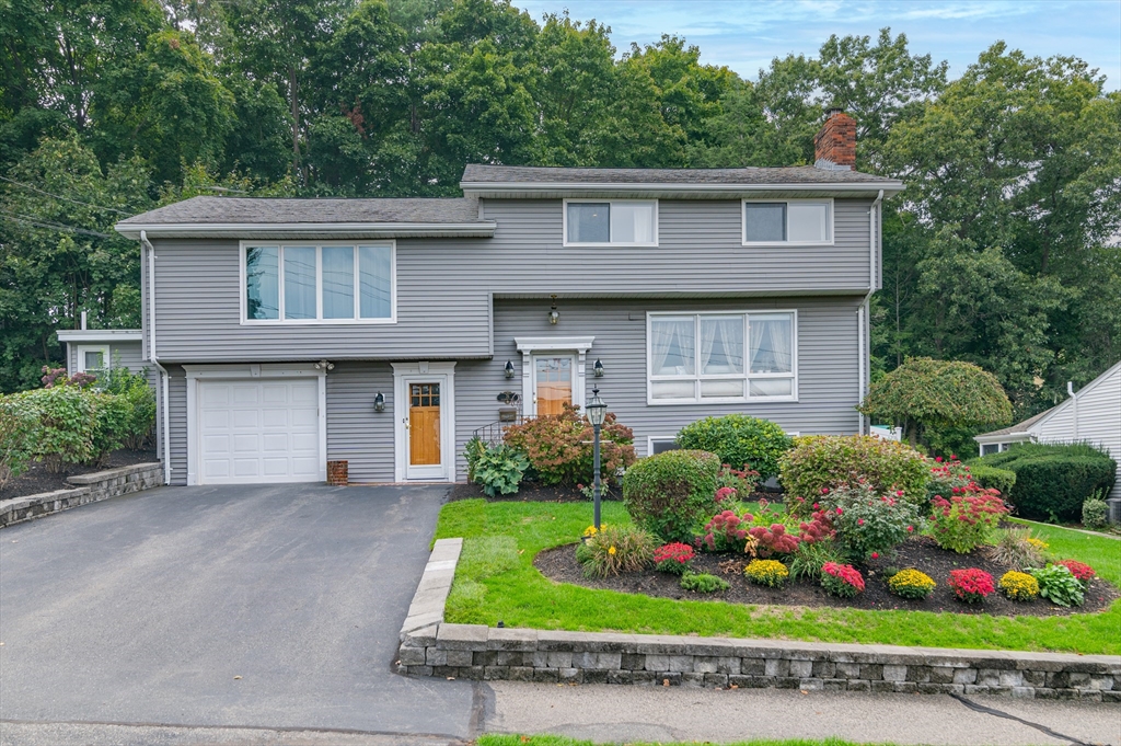 a front view of a house with a yard and potted plants