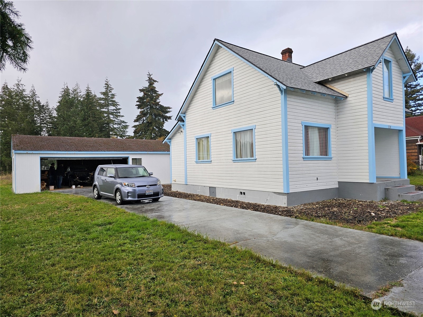 a view of a house with a barbeque grill and a small yard