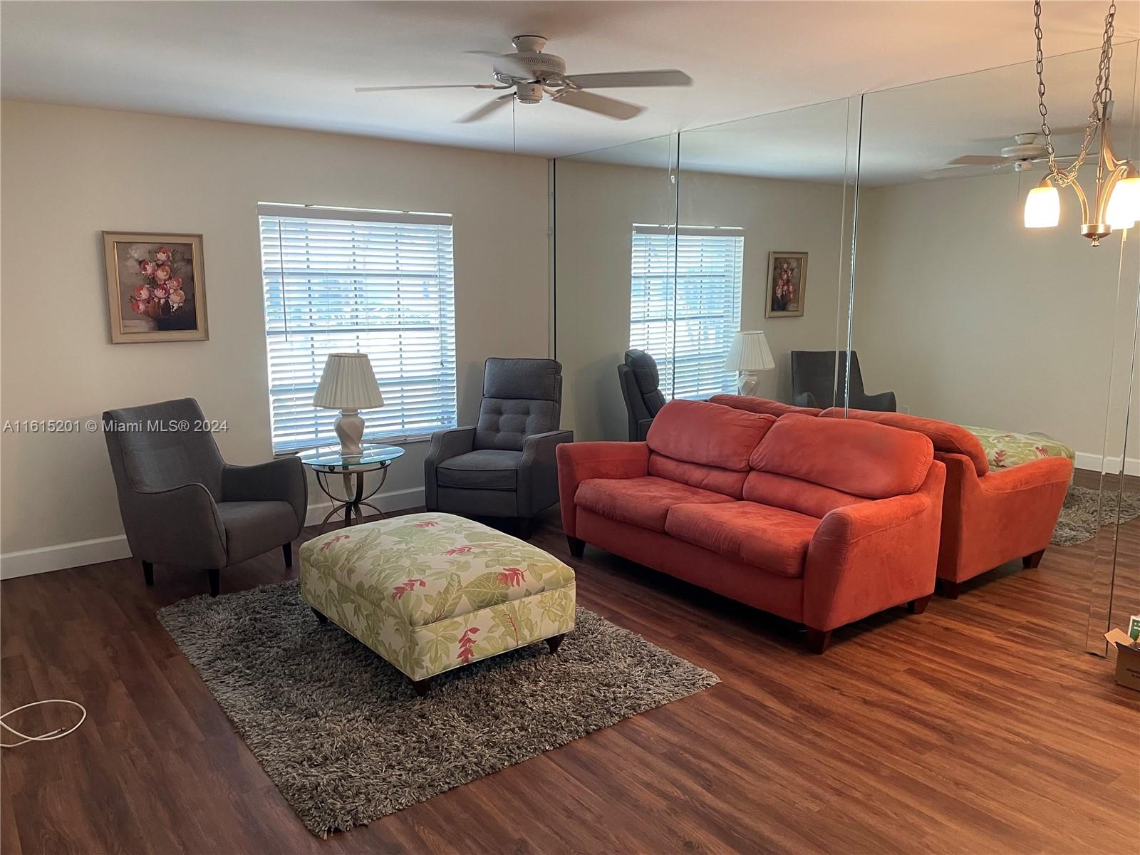 a living room with furniture ceiling fan and a window