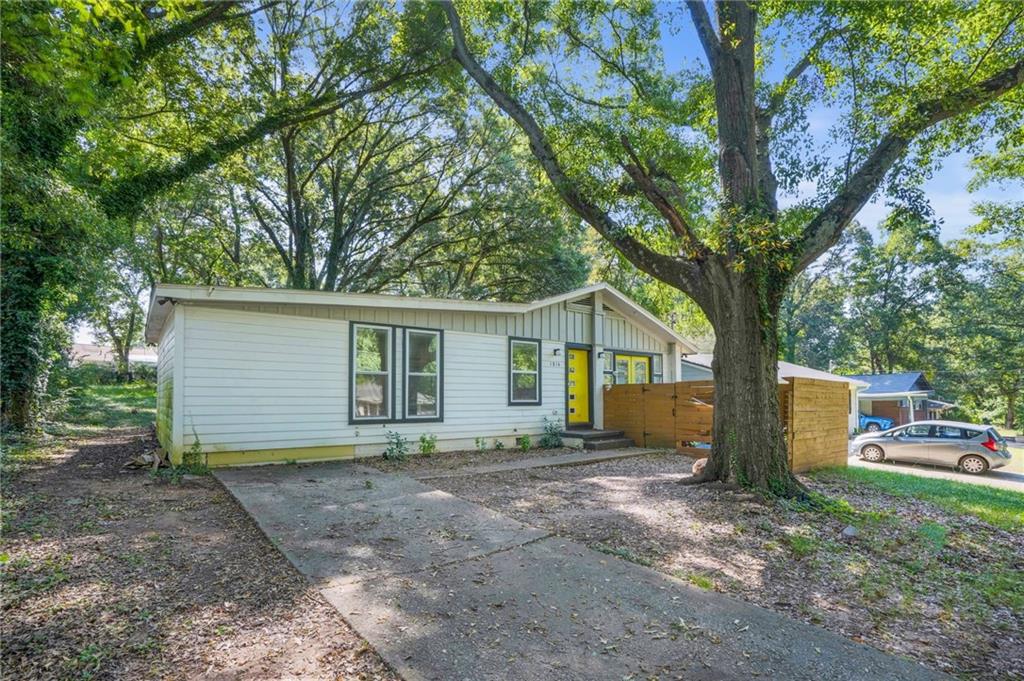 a view of a house with a yard and large tree