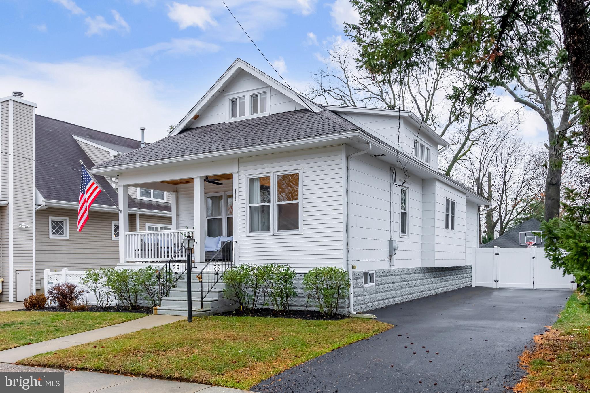 a front view of a house with a yard and potted plants