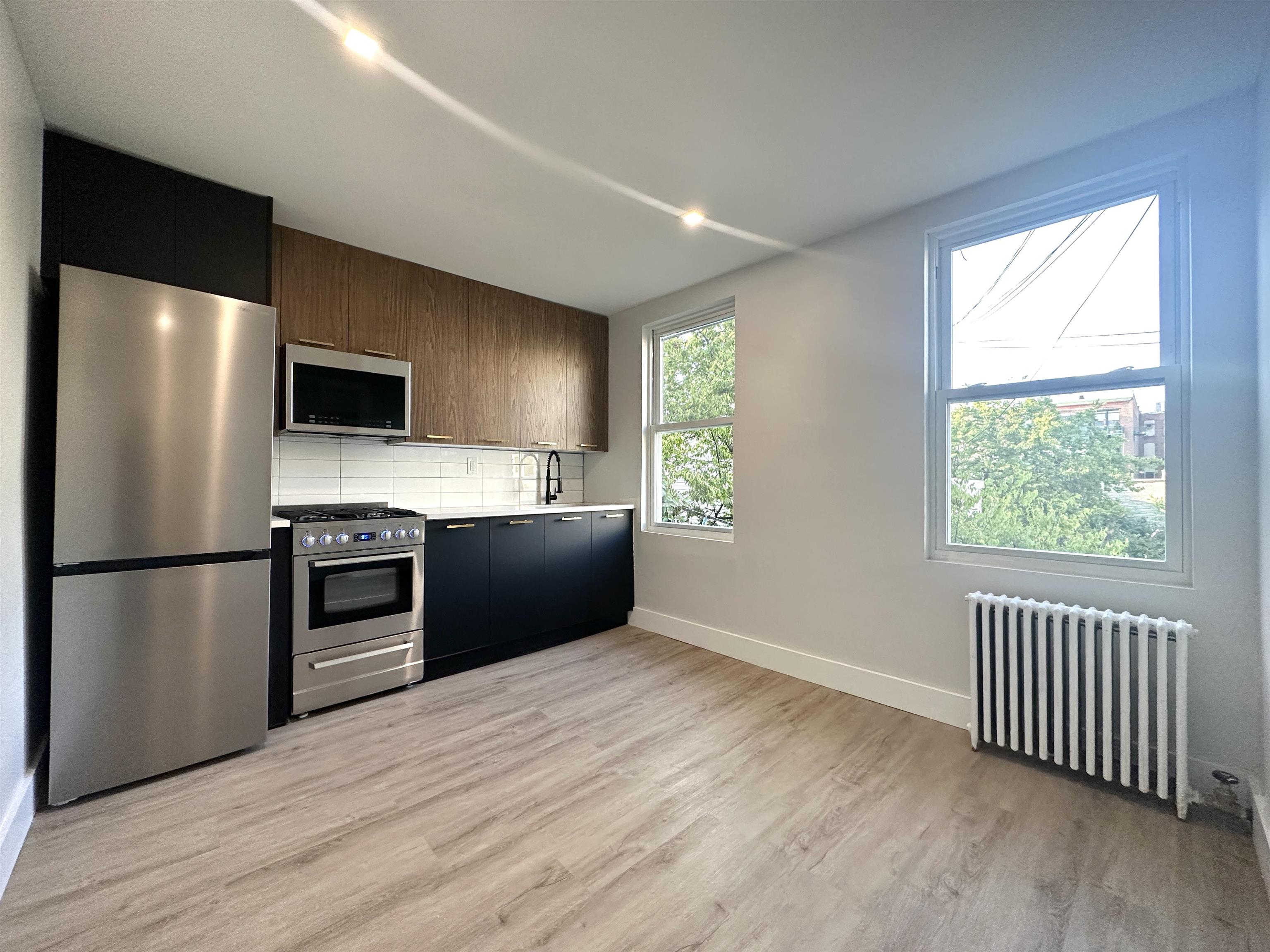 a kitchen with a refrigerator and a stove top oven