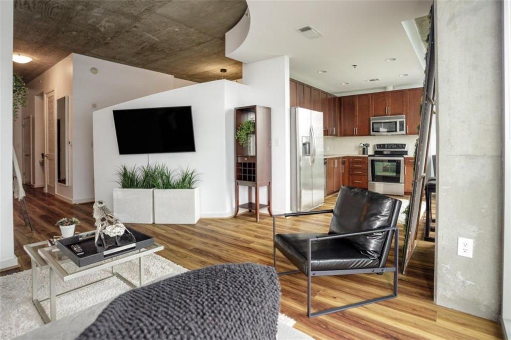 a living room with furniture a flat screen tv and a table