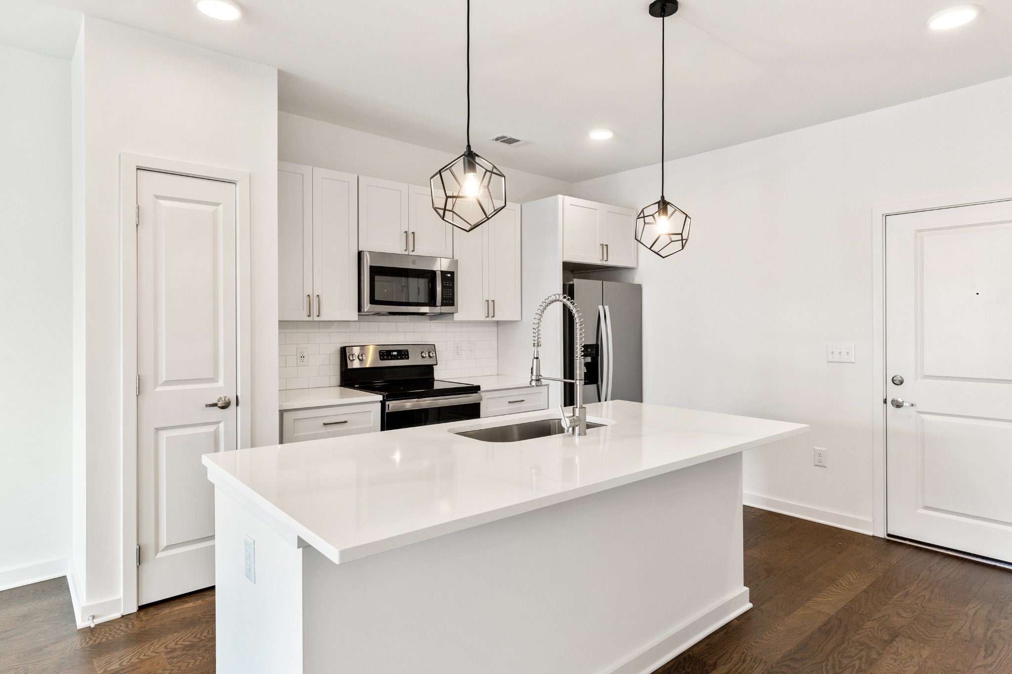 a kitchen with a sink a refrigerator and chairs