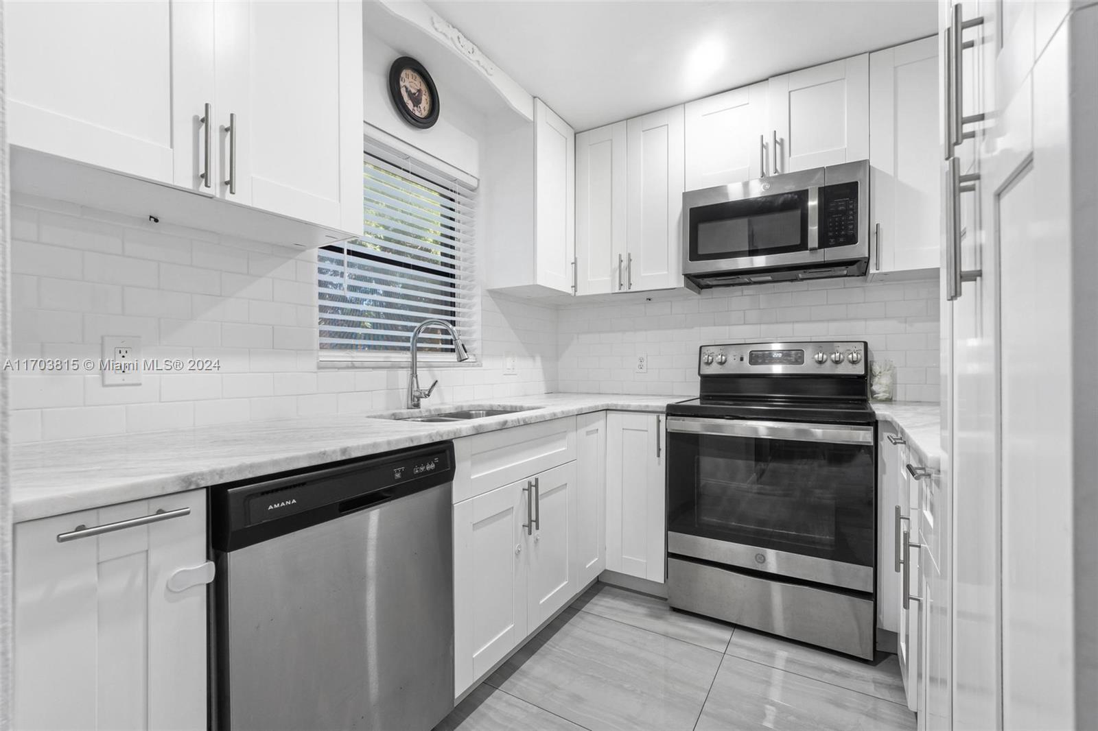 a kitchen with stainless steel appliances granite countertop a sink stove and microwave