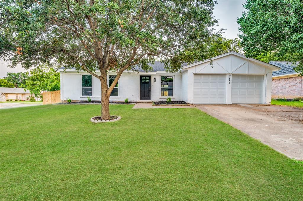 a front view of house with yard and trees