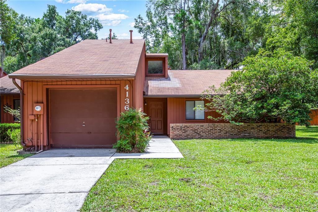 a front view of a house with a yard and trees