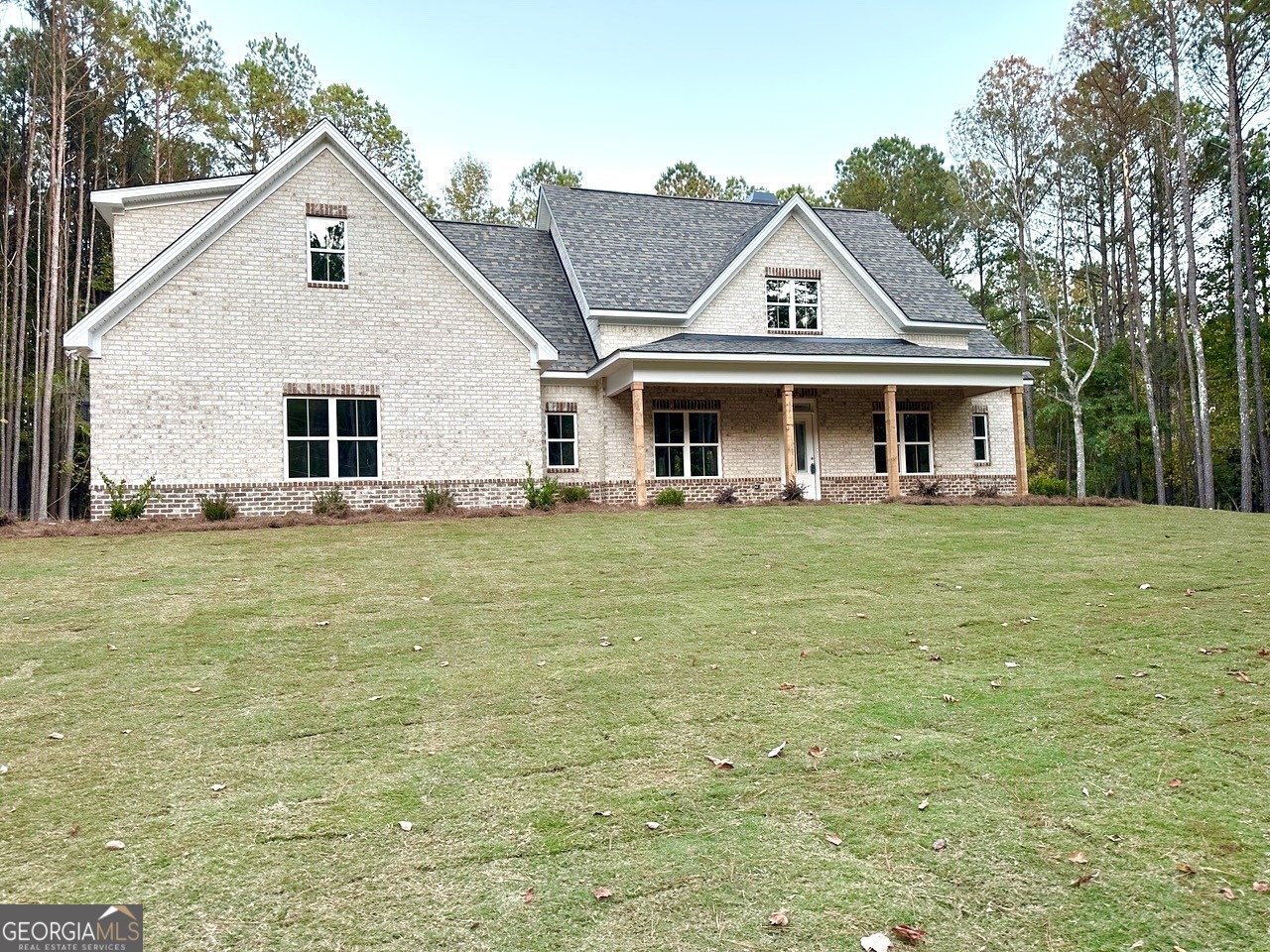 a front view of house with yard and trees in the background