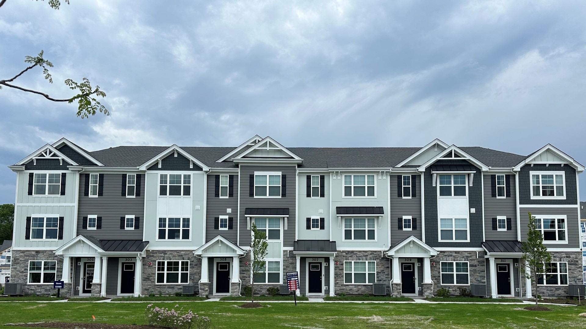 a front view of residential houses with yard and green space