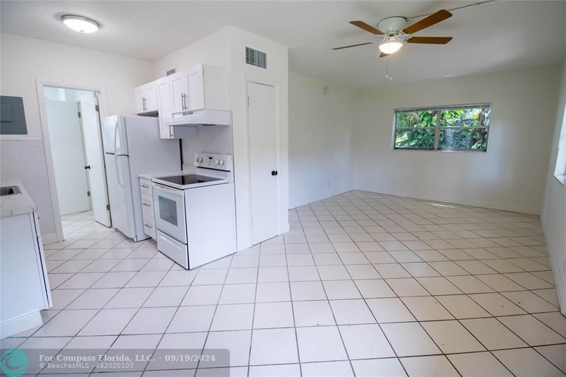 a kitchen with stainless steel appliances a stove refrigerator sink and white cabinets