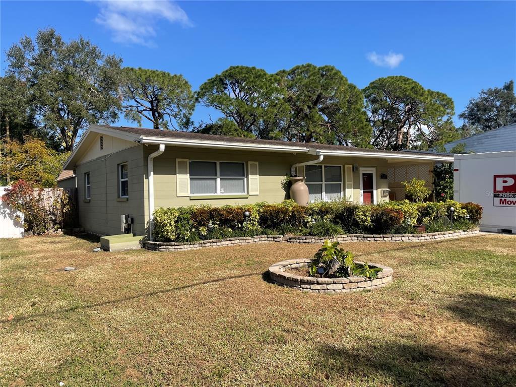 a view of a house with backyard and sitting area