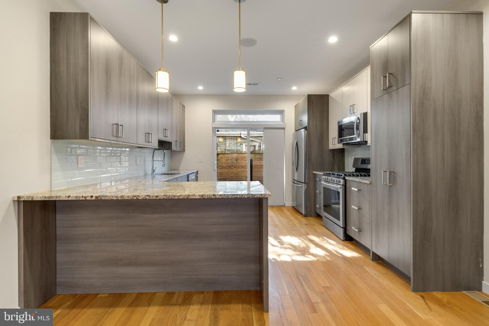 a large kitchen with kitchen island a sink stainless steel appliances and cabinets