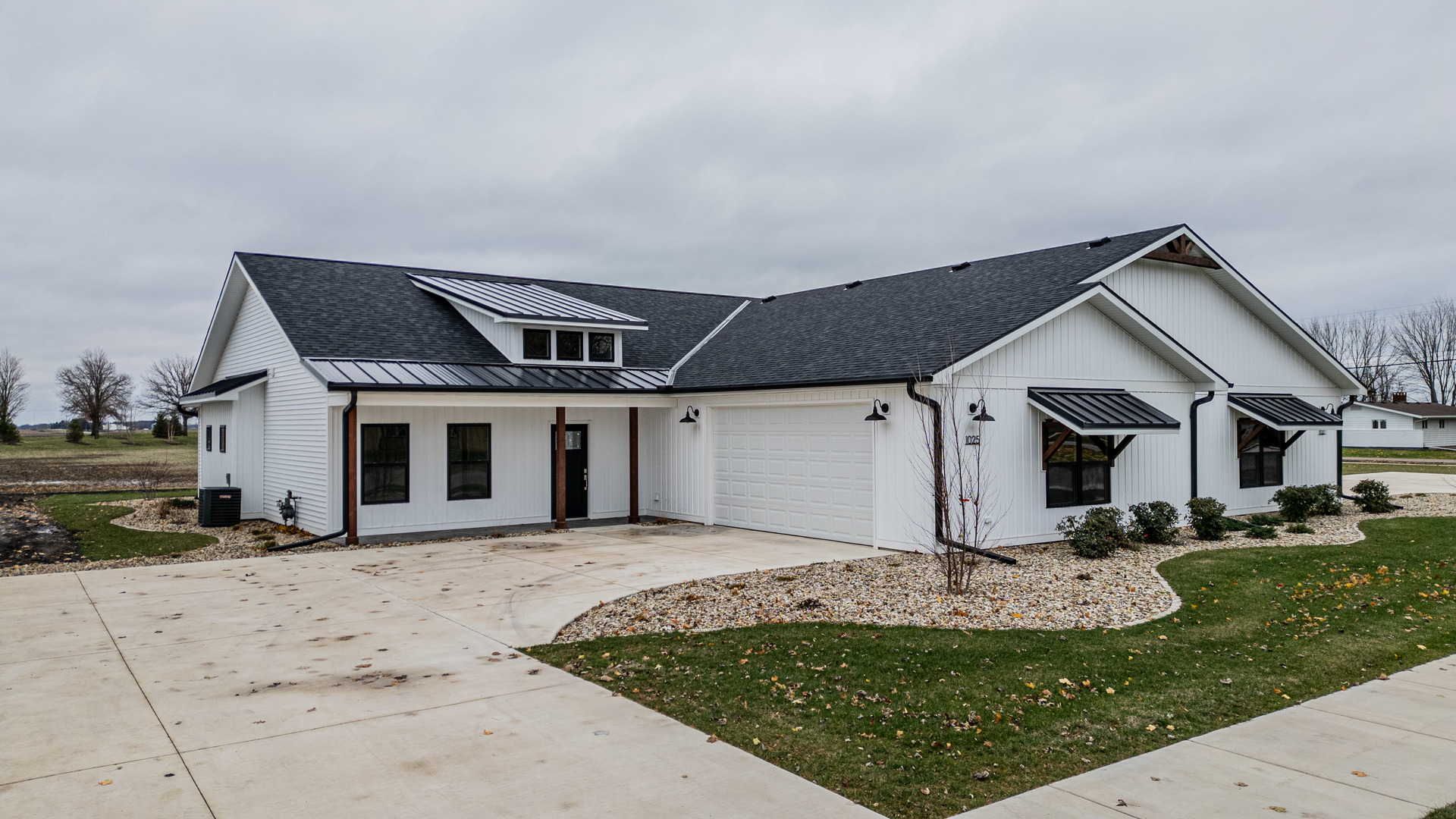 a front view of house with yard and trees in the background