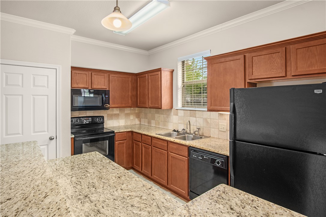 Kitchen featuring backsplash, black appliances, cr