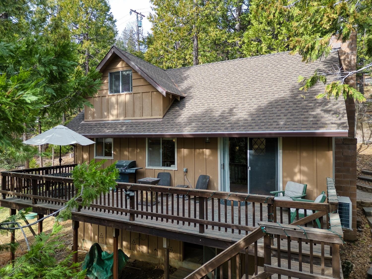 a view of a house with wooden deck and furniture