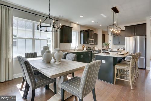 a dining room with furniture a chandelier and wooden floor