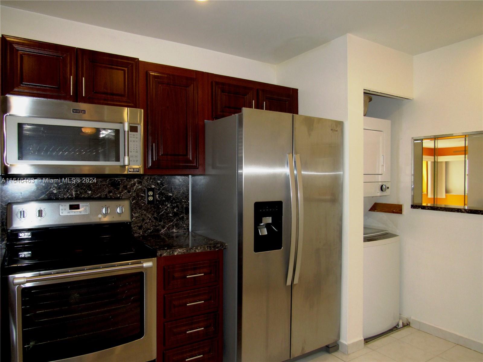 a kitchen with stainless steel appliances granite countertop a refrigerator and a stove top oven