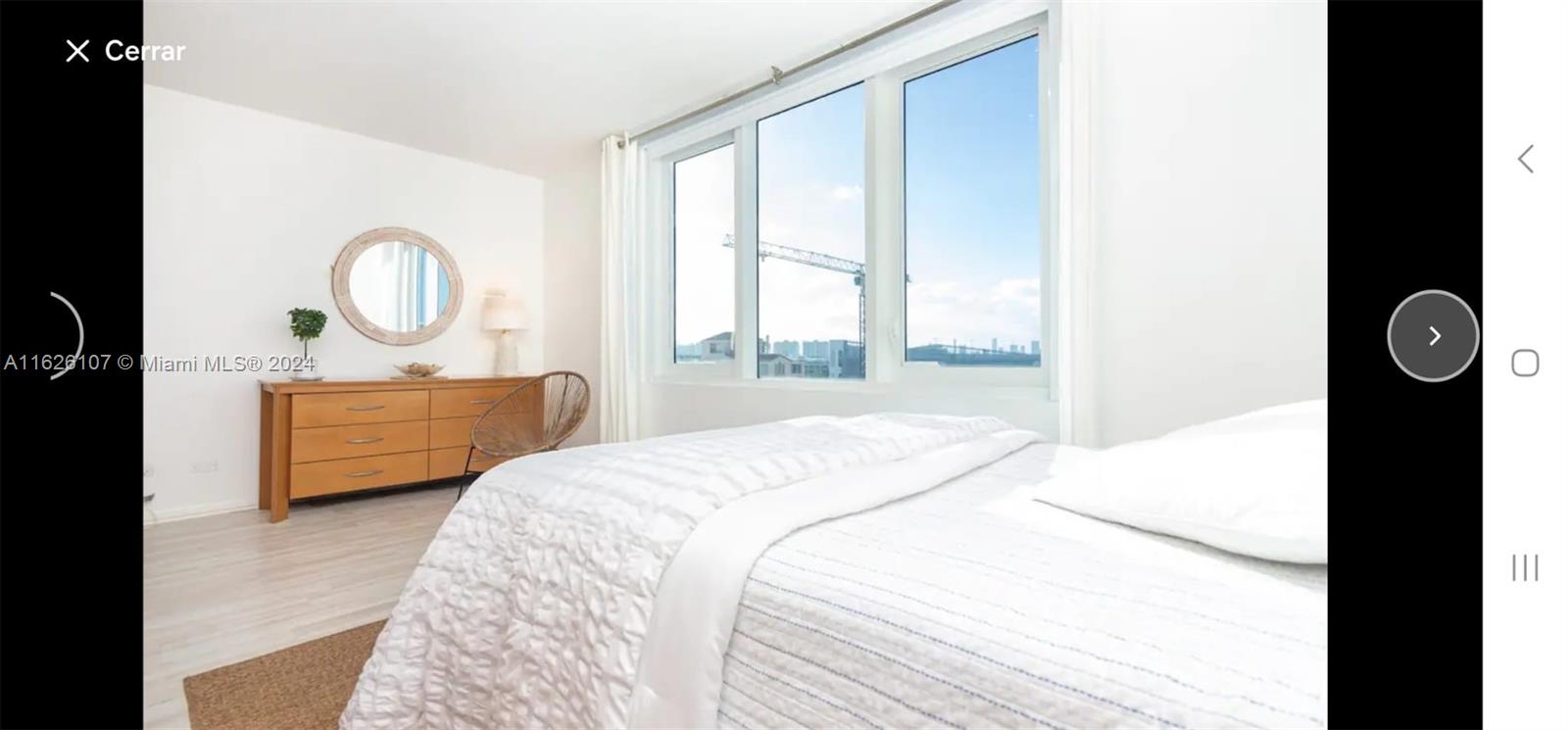 a bedroom with a bed mirror and window