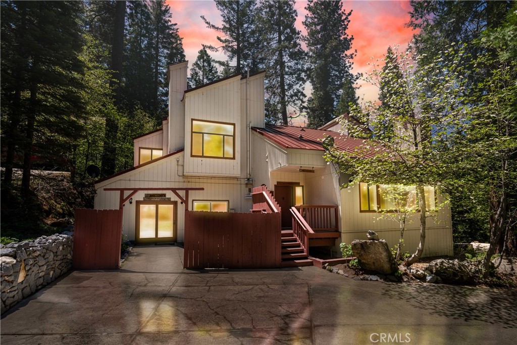 a view of a house with backyard and trees