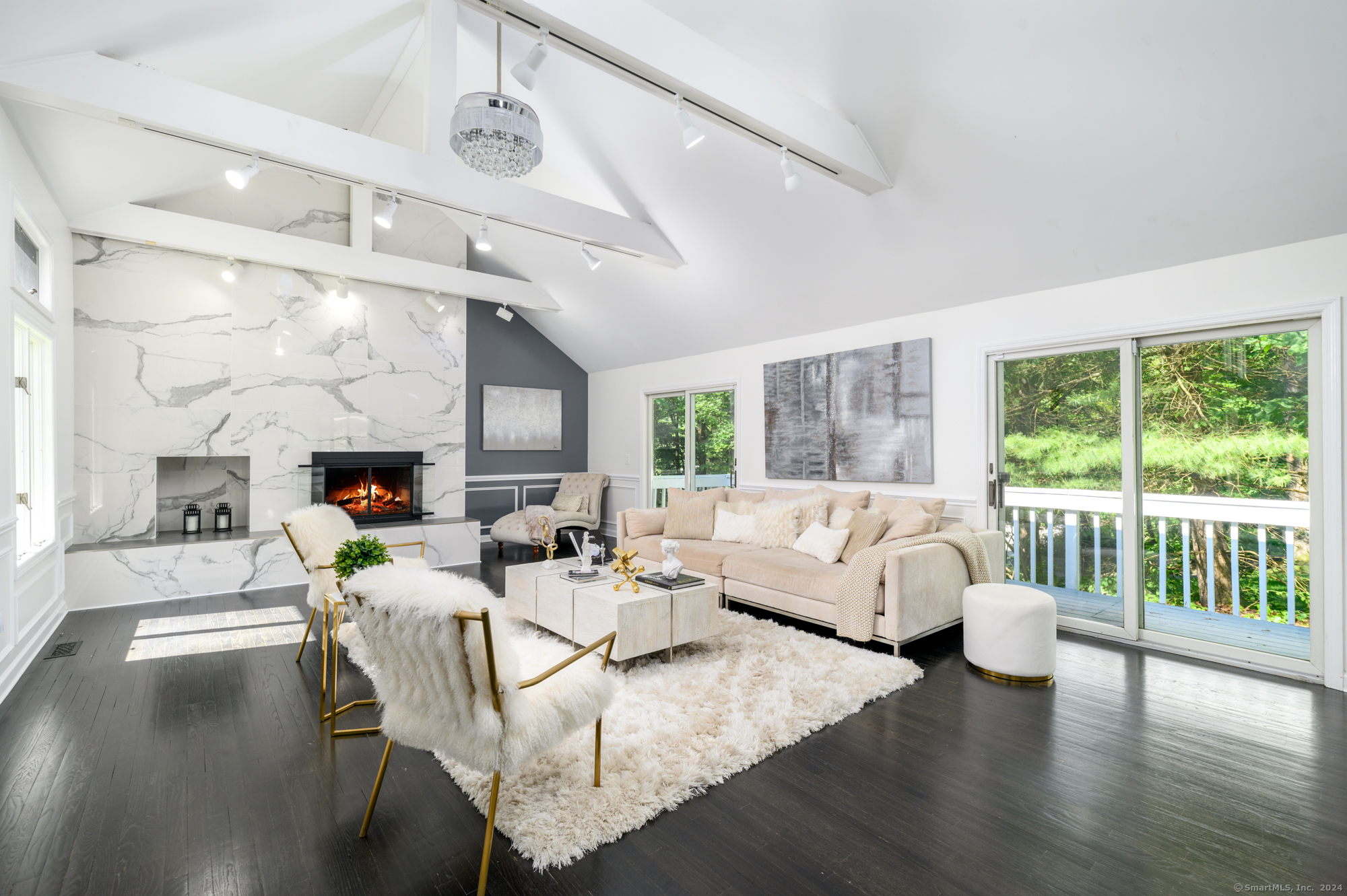 a living room with fireplace furniture and a large window