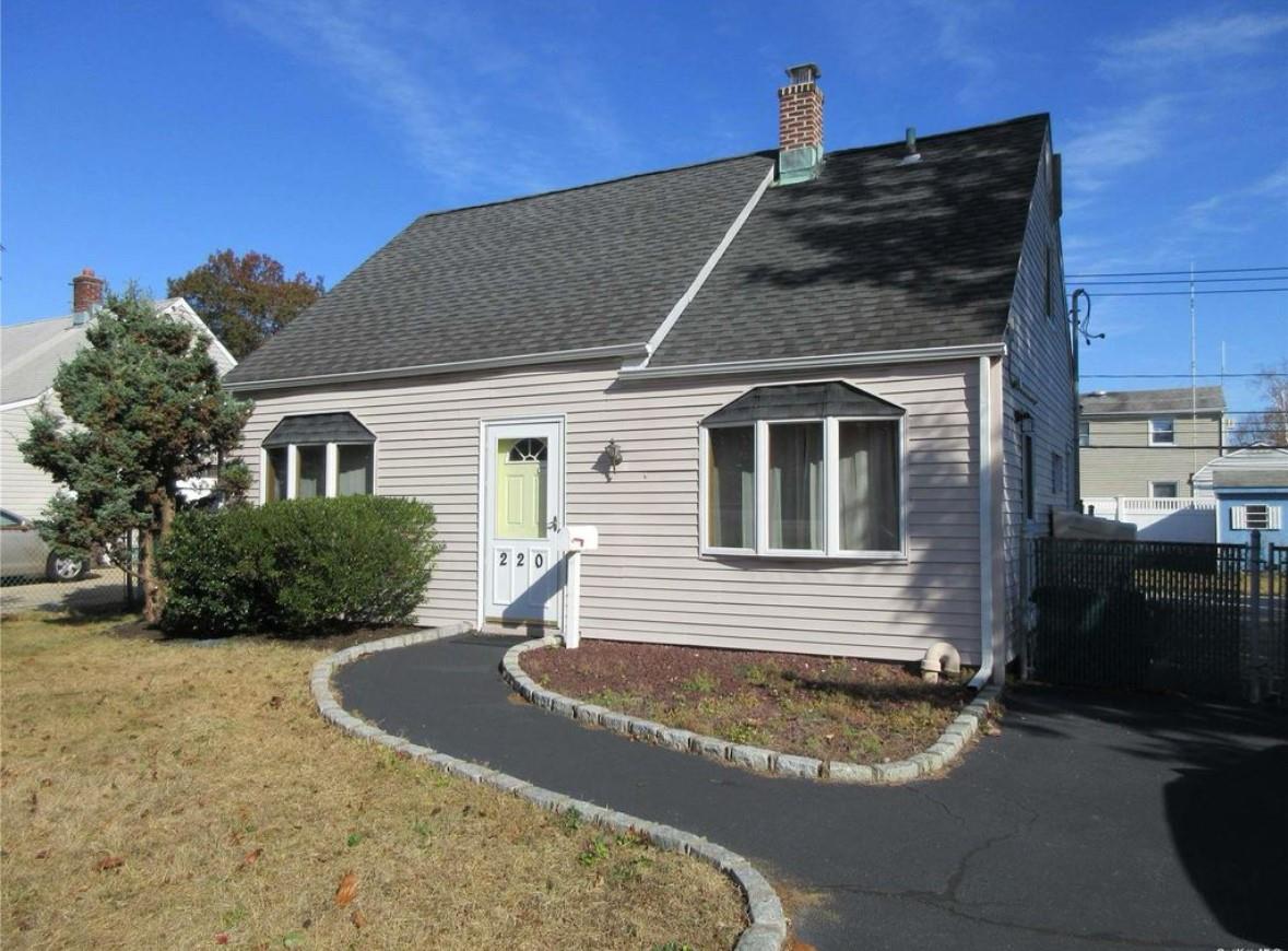 Cape style house with a front yard and driveway