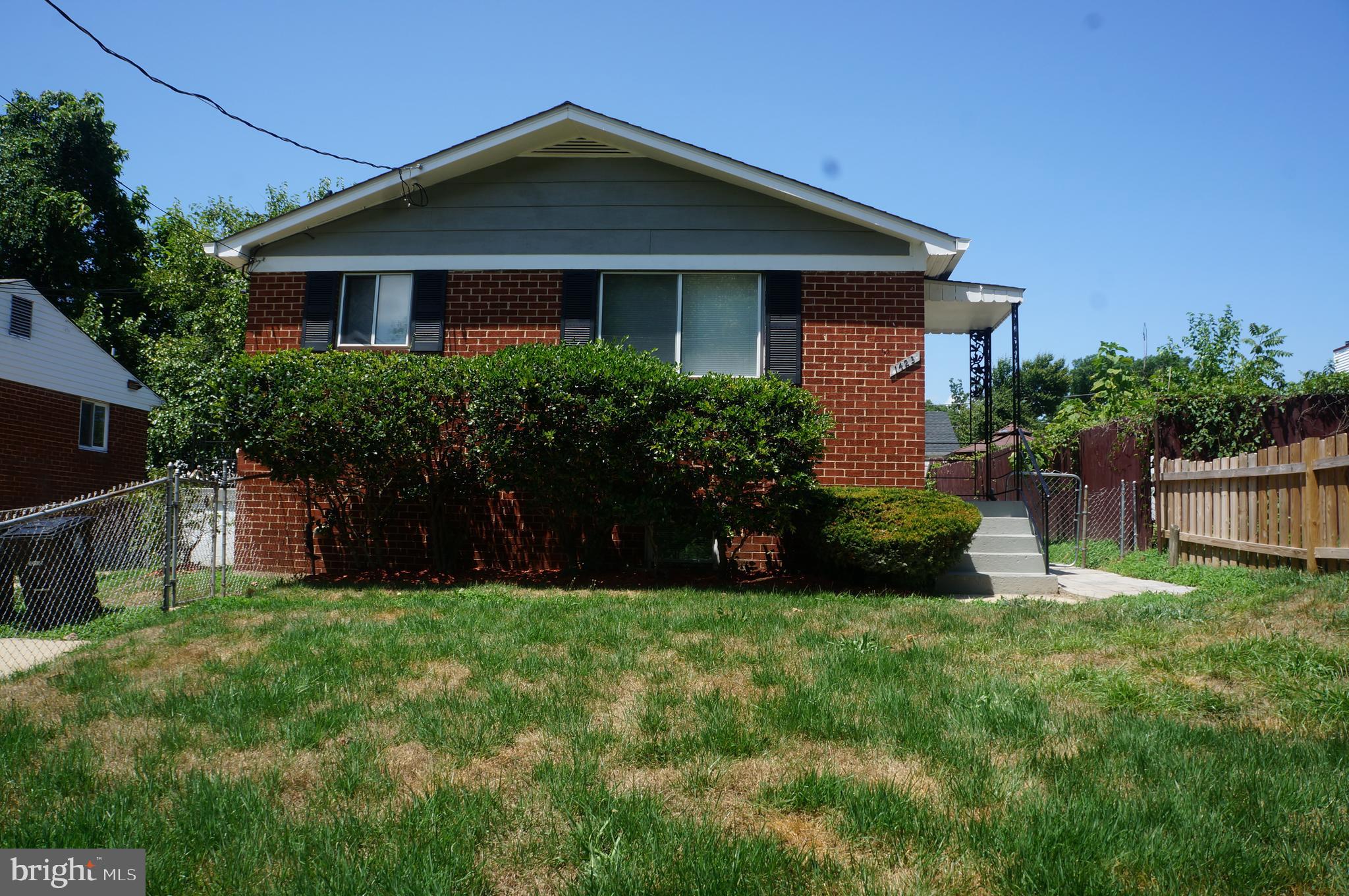 a front view of a house with a yard and plants