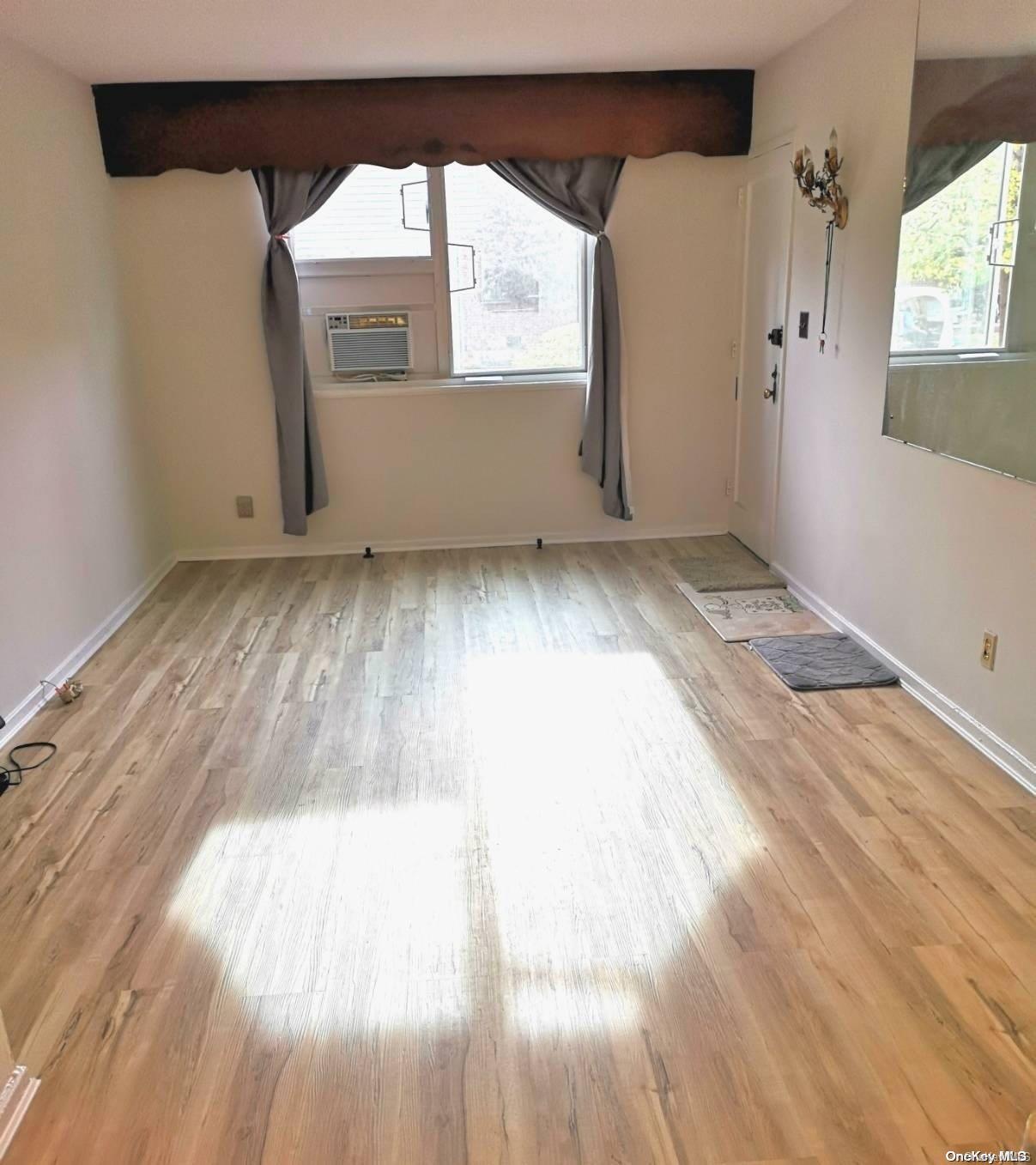 a view of a room with wooden floor and a window