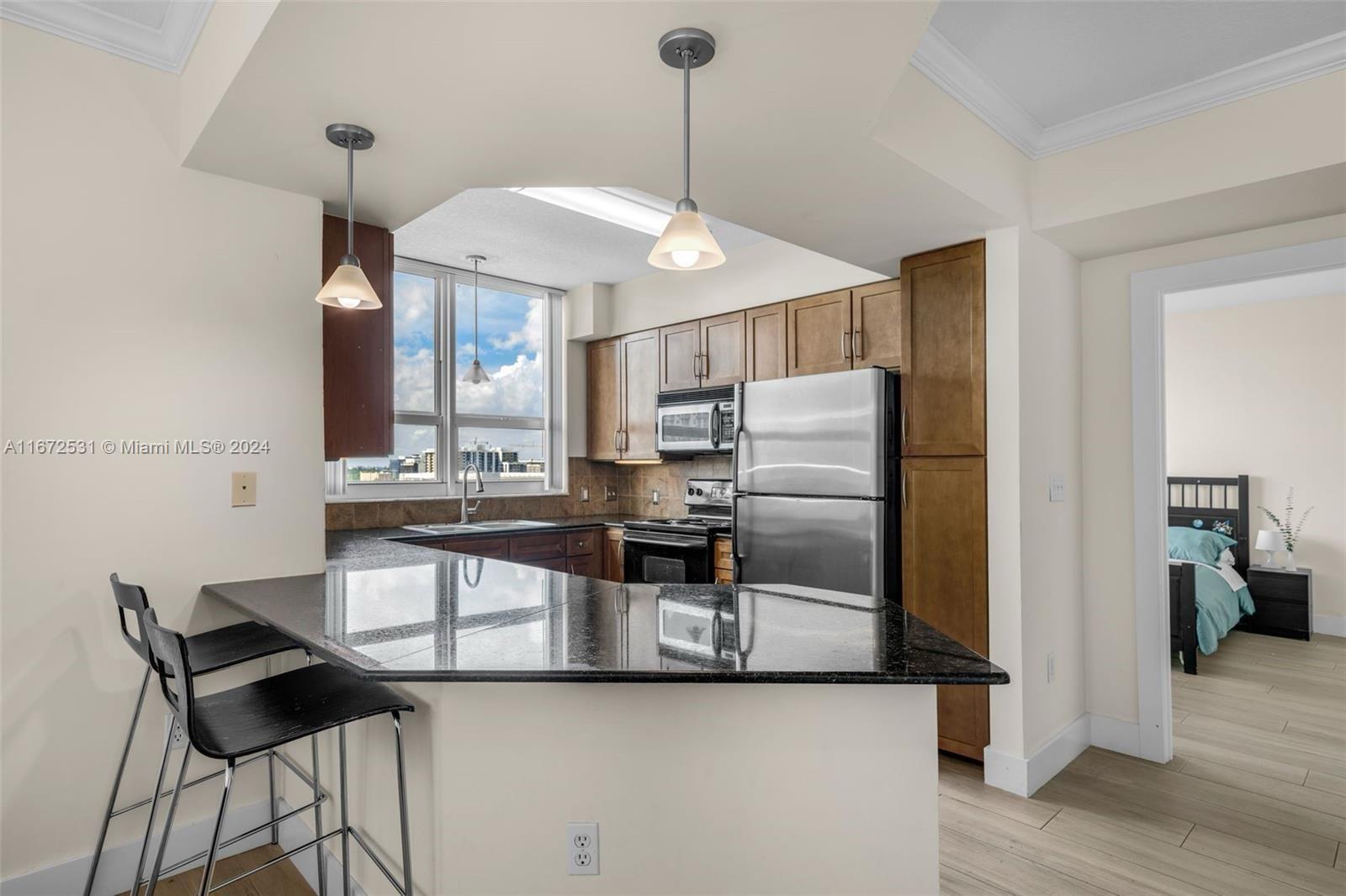 a kitchen with stainless steel appliances a dining table chairs and a refrigerator