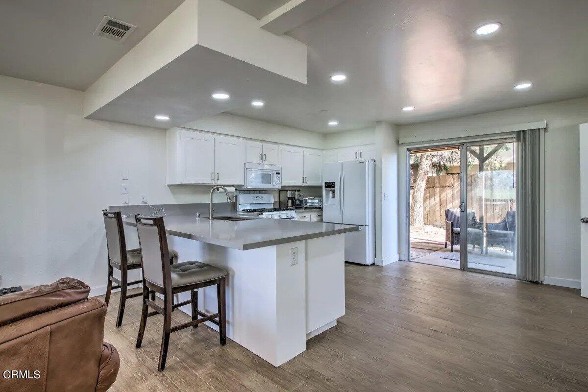 a kitchen with stainless steel appliances granite countertop a stove top oven a sink and a refrigerator