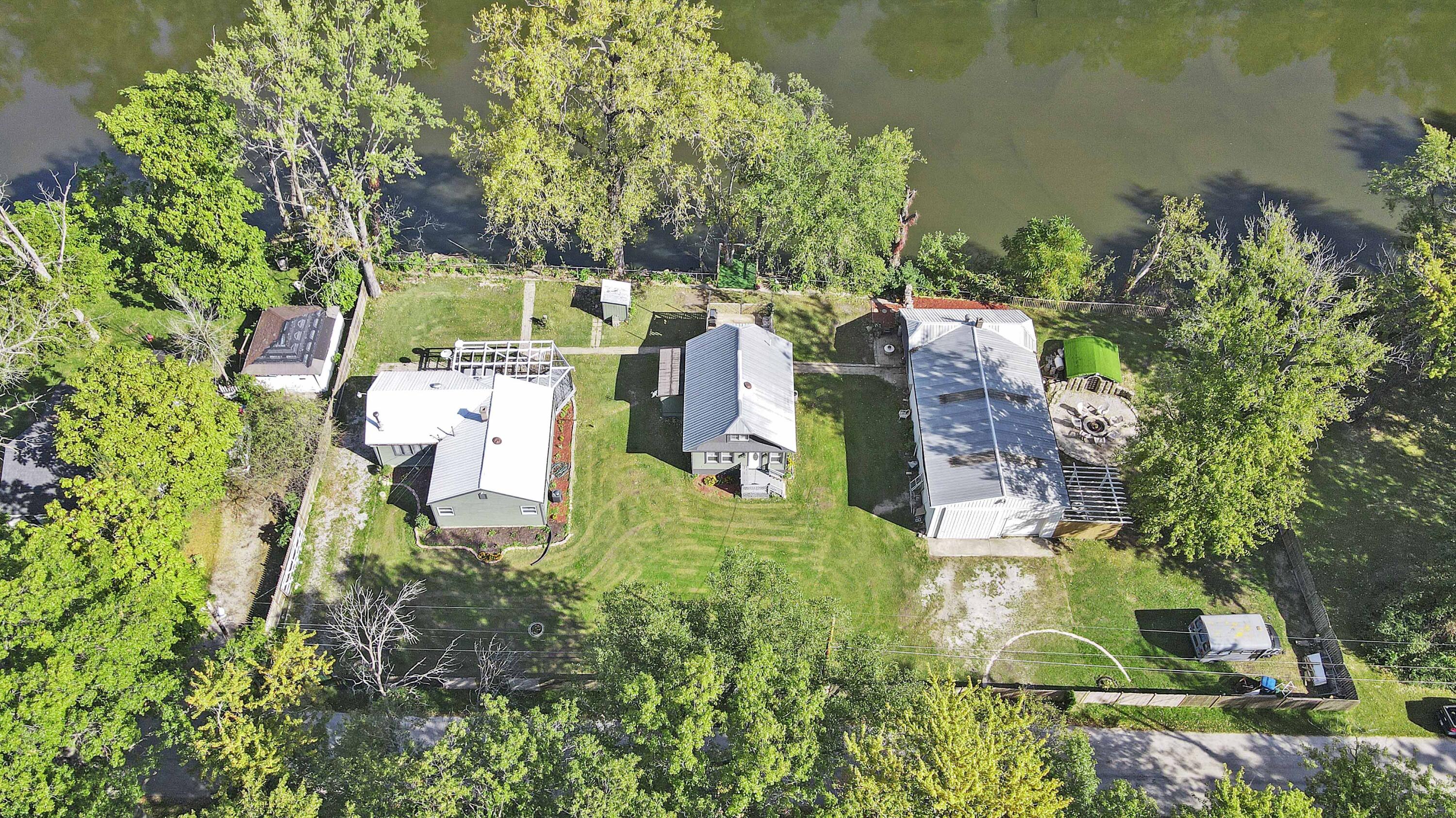 an aerial view of residential house with outdoor space and trees all around