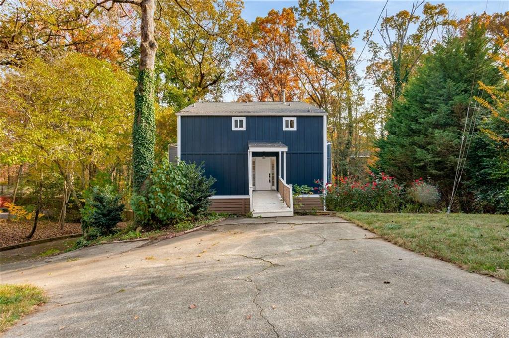 a view of a house with backyard and trees