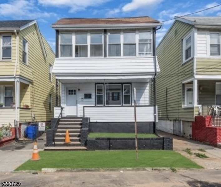 a view of a house with a yard and sitting area