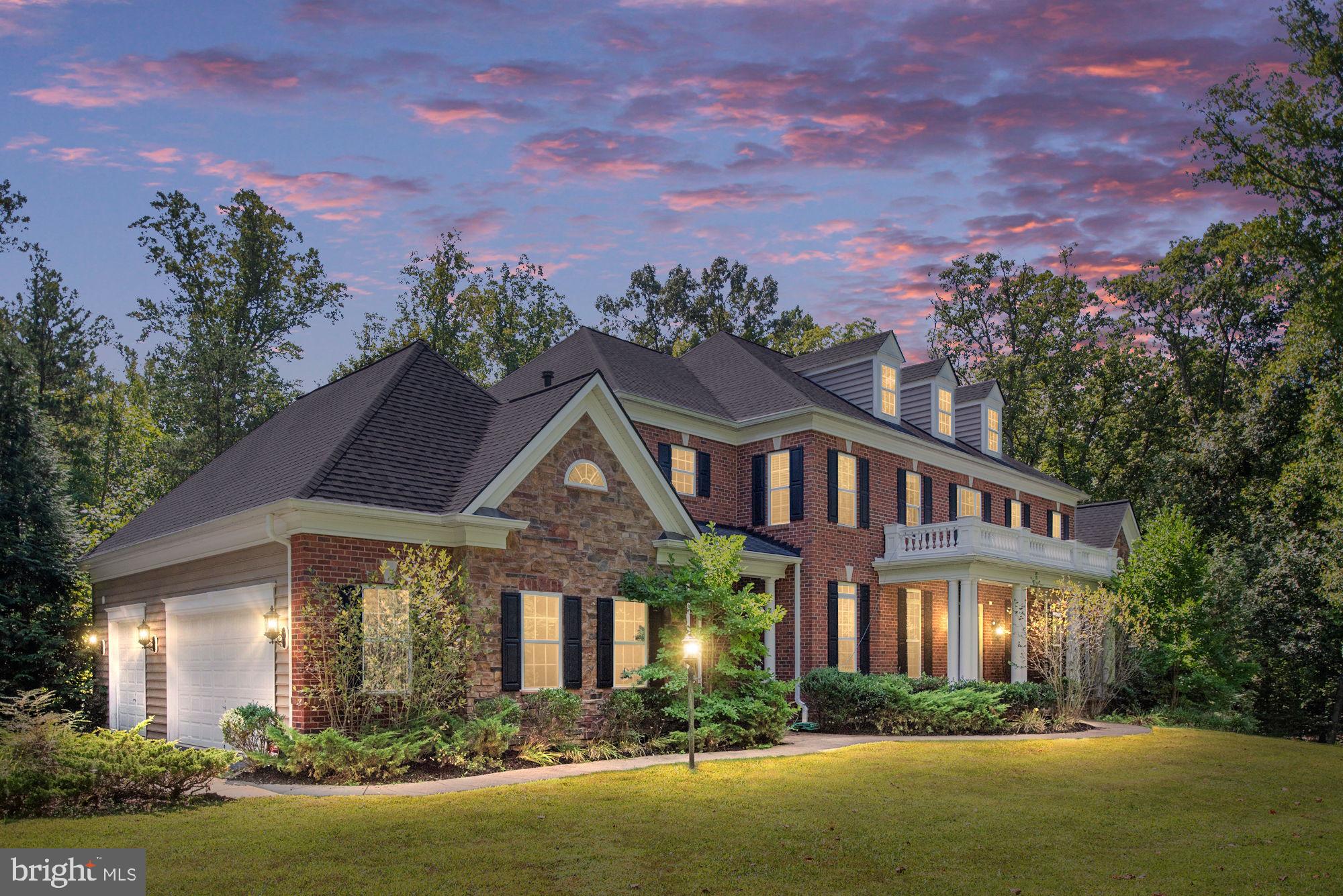 a front view of a house with a yard and lake view