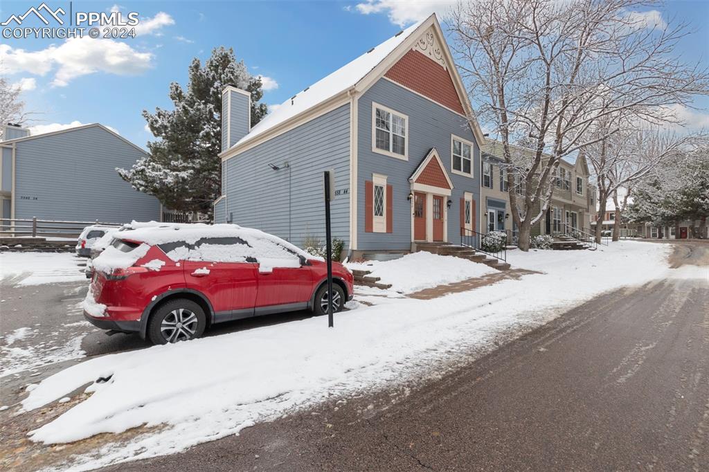 a front view of a house with a yard covered in snow