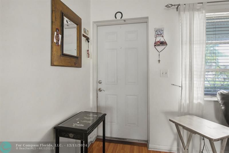 a view of a hallway with front door and stairs