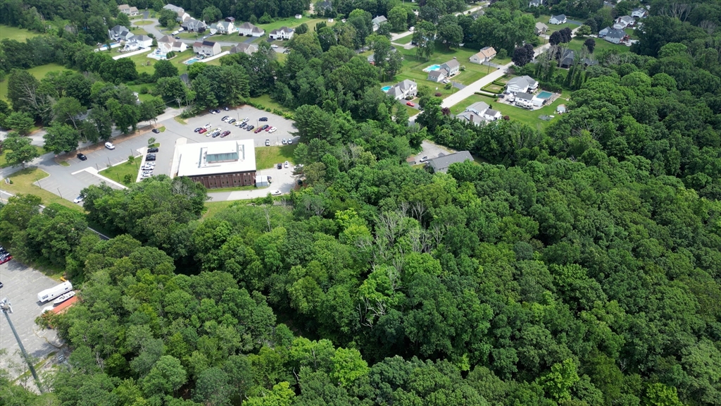 an aerial view of residential house with outdoor space and trees all around