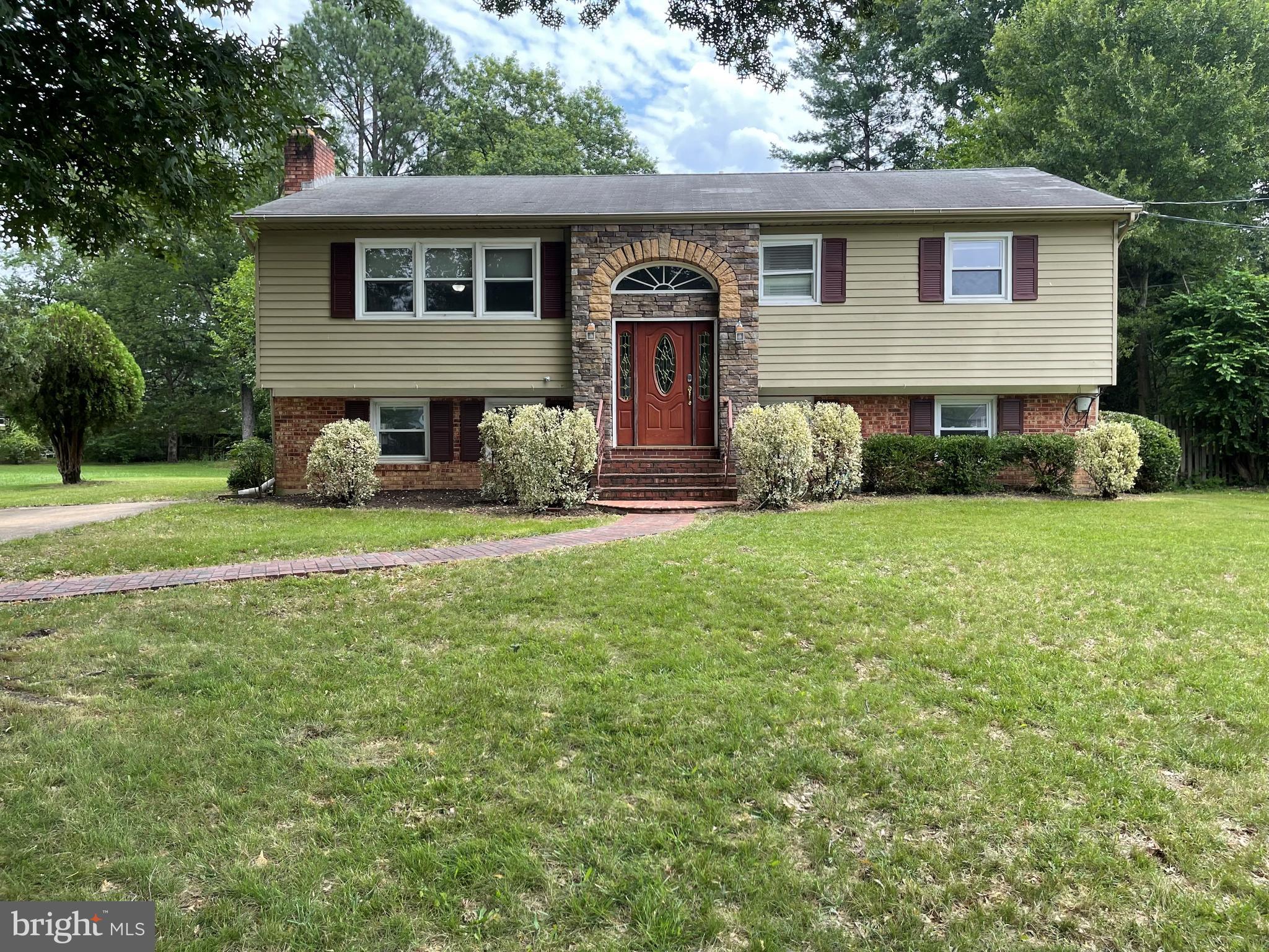 a front view of a house with yard and green space