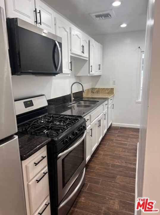 a kitchen with stainless steel appliances granite countertop a stove and a microwave