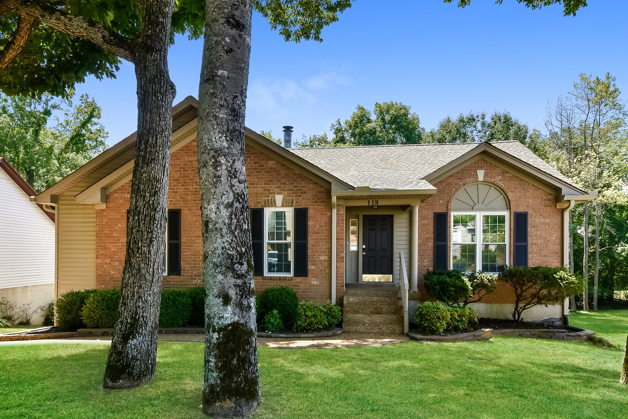 a front view of a house with a yard and potted plants