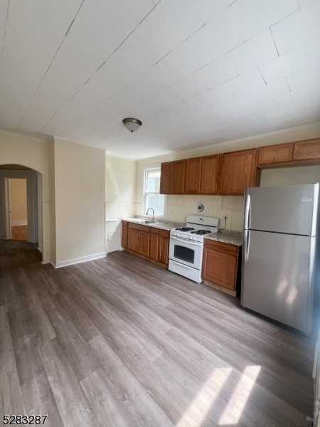 a kitchen with stainless steel appliances granite countertop a stove a sink dishwasher and a refrigerator