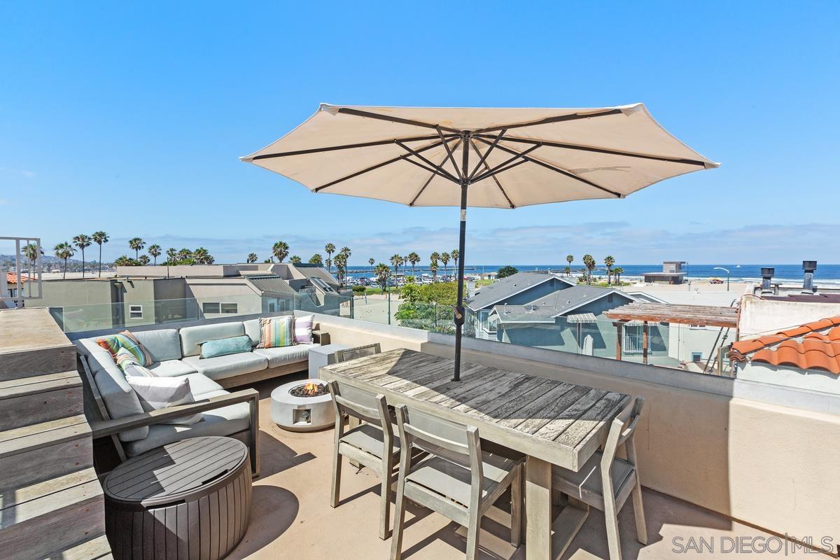 a view of a terrace with furniture and an umbrella