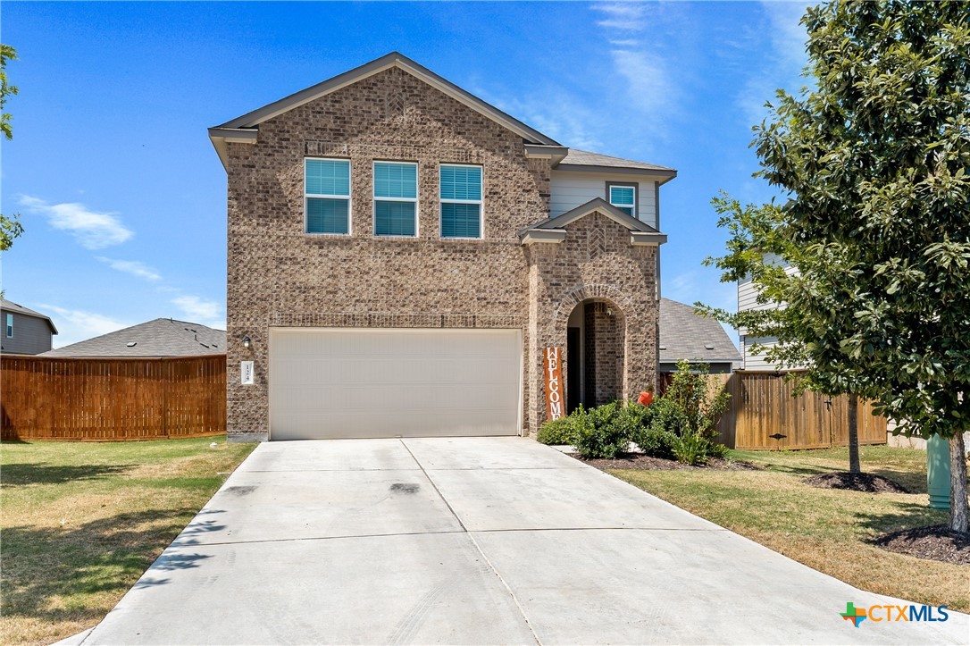 a front view of a house with a yard and a garage