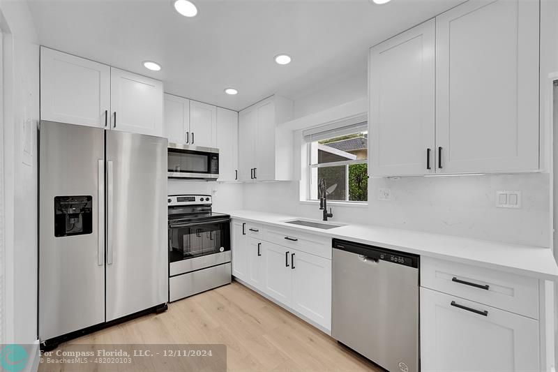 a kitchen with white cabinets and stainless steel appliances