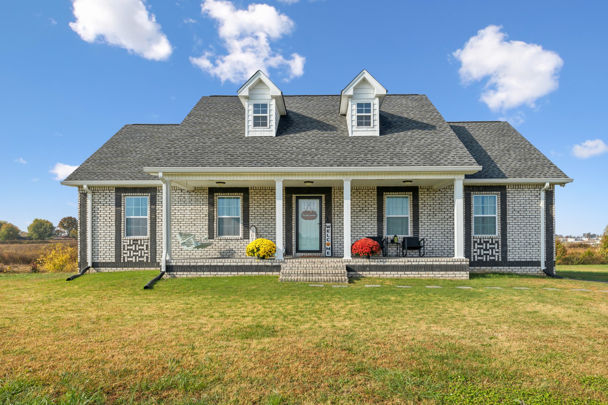 a front view of a house with a garden and plants