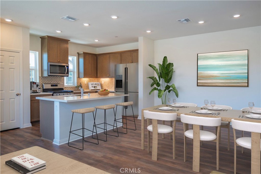 a kitchen with kitchen island granite countertop wooden floor cabinets and stainless steel appliances